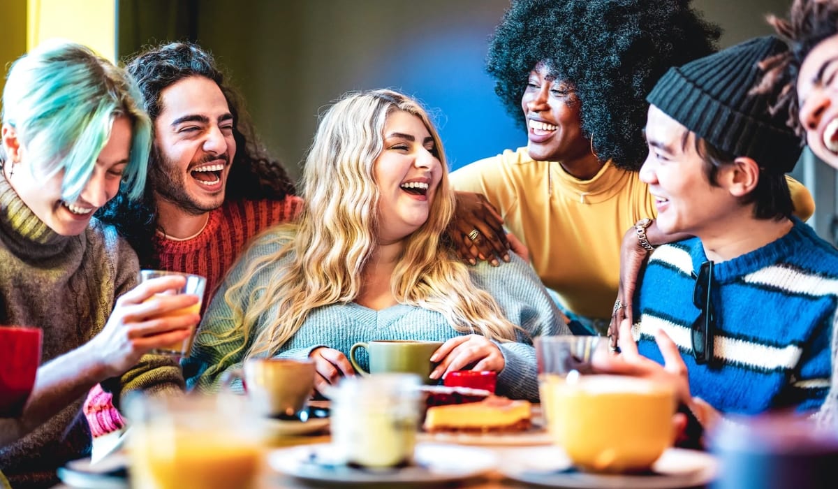 Diverse group of people laughing and enjoying tea together